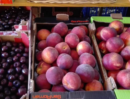 Cajas de hortalizas y frutas frescas de temporada expuestas en el interior de La Tiendina de Chelo, Bembibre.
